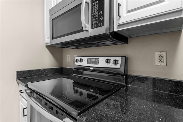 kitchen with appliances with stainless steel finishes, dark countertops, and white cabinetry