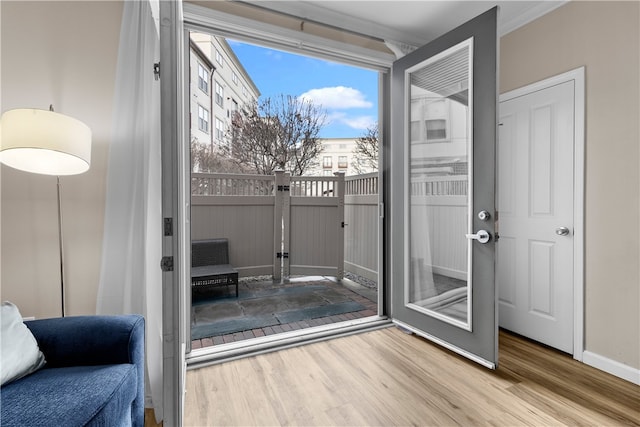 doorway featuring wood finished floors and baseboards