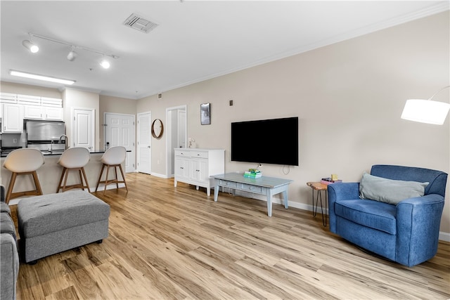 1000 Providence Pl Unit 106, Providence, RI 02903 - living room featuring visible vents, ornamental molding, track lighting, baseboards, and light wood-type flooring
