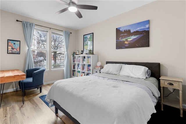 bedroom with ceiling fan, wood finished floors, and baseboards