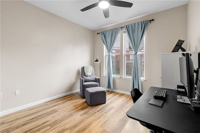 home office with baseboards, ceiling fan, and light wood finished floors