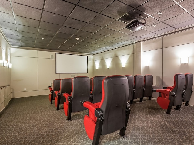 cinema with a paneled ceiling, visible vents, and carpet flooring