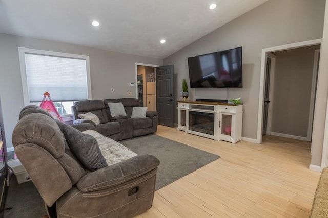 living area featuring baseboards, wood finished floors, vaulted ceiling, a fireplace, and recessed lighting