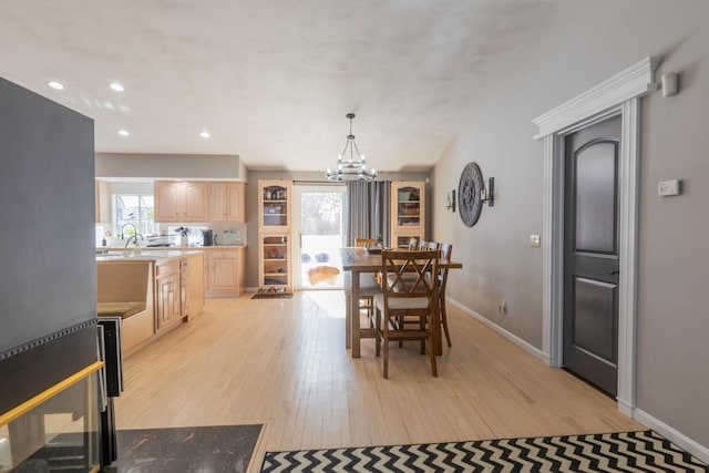 dining area featuring baseboards, recessed lighting, light wood-style flooring, and an inviting chandelier