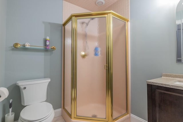 bathroom with a shower stall, toilet, and vanity