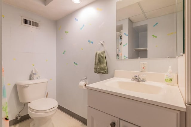 bathroom featuring toilet, a paneled ceiling, vanity, visible vents, and baseboards