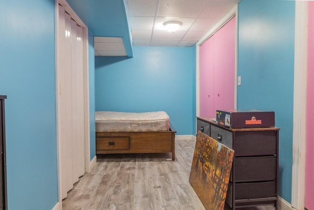 hall featuring wood finished floors, a paneled ceiling, and baseboards