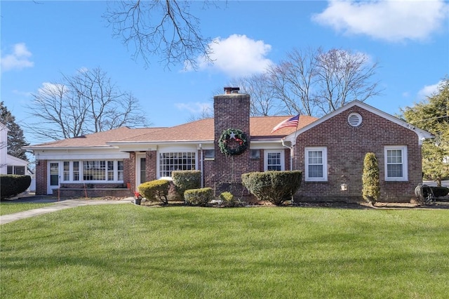 ranch-style home with brick siding, a chimney, and a front yard