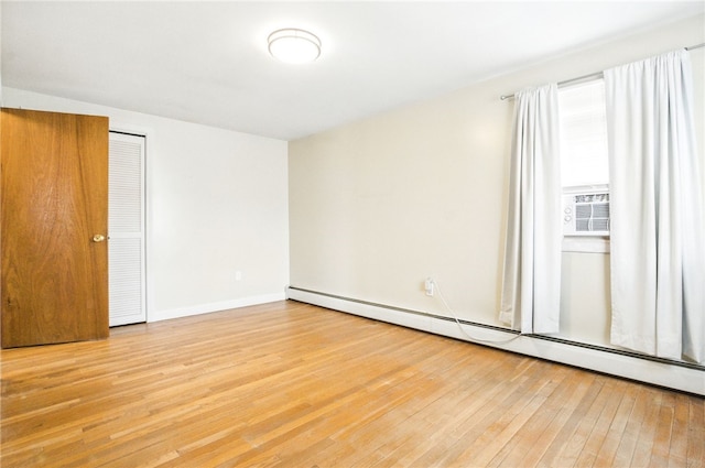 unfurnished bedroom with light wood finished floors, baseboards, baseboard heating, and cooling unit