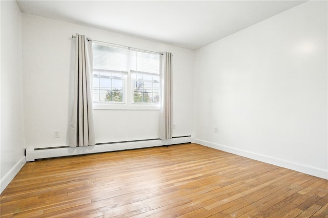 unfurnished room with a baseboard radiator, baseboards, and light wood-style flooring