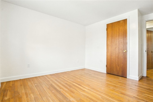 unfurnished room with light wood-style flooring and baseboards