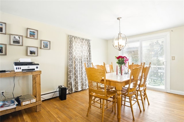 dining space with a baseboard heating unit, an inviting chandelier, baseboards, and light wood-style floors