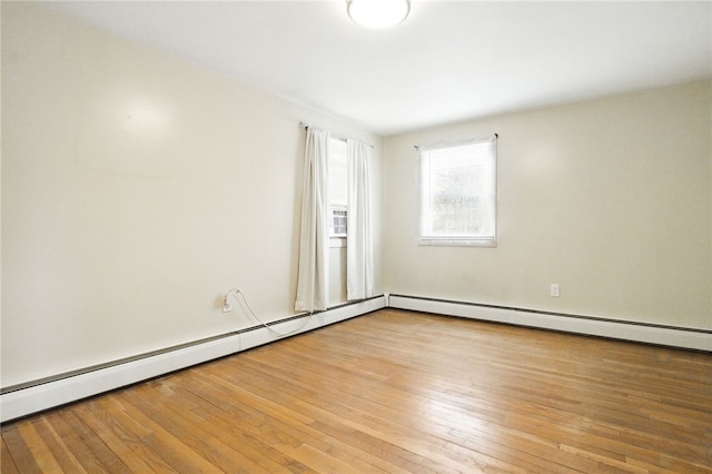 spare room featuring a baseboard radiator and hardwood / wood-style floors