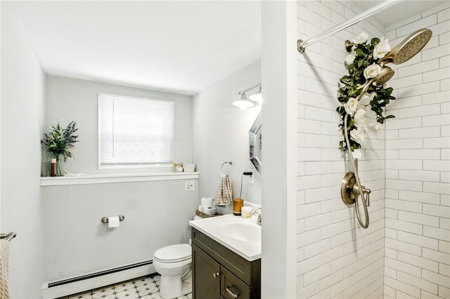 bathroom with toilet, vanity, baseboard heating, a tile shower, and tile patterned floors