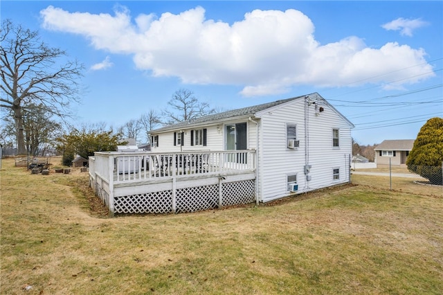 rear view of property featuring a yard, cooling unit, and a wooden deck