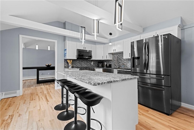 kitchen featuring light wood-type flooring, stainless steel refrigerator with ice dispenser, and decorative backsplash