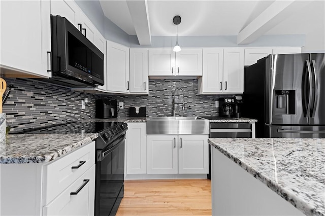 kitchen with electric range, light wood-style floors, white cabinetry, a sink, and stainless steel fridge