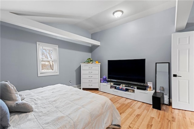 bedroom featuring light wood-style floors and lofted ceiling