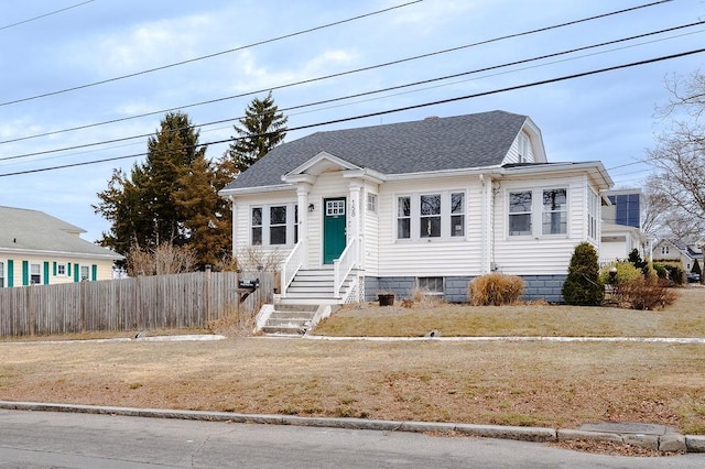 bungalow-style house with entry steps, crawl space, a shingled roof, and fence