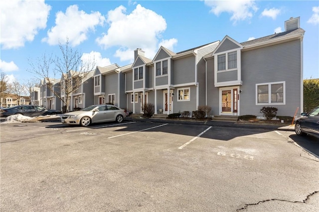 view of building exterior featuring uncovered parking and a residential view