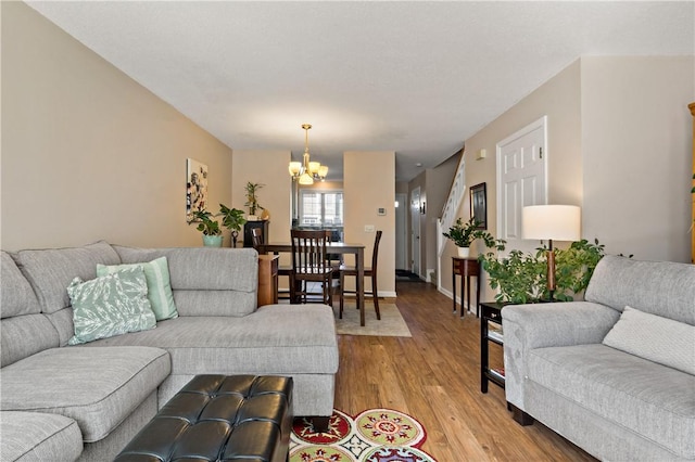 living area with light wood finished floors, baseboards, and a notable chandelier