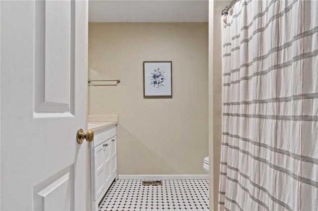 full bathroom featuring toilet, a shower with curtain, baseboards, and vanity