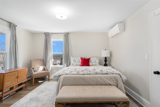 bedroom with baseboard heating, wood finished floors, baseboards, and a wall mounted AC