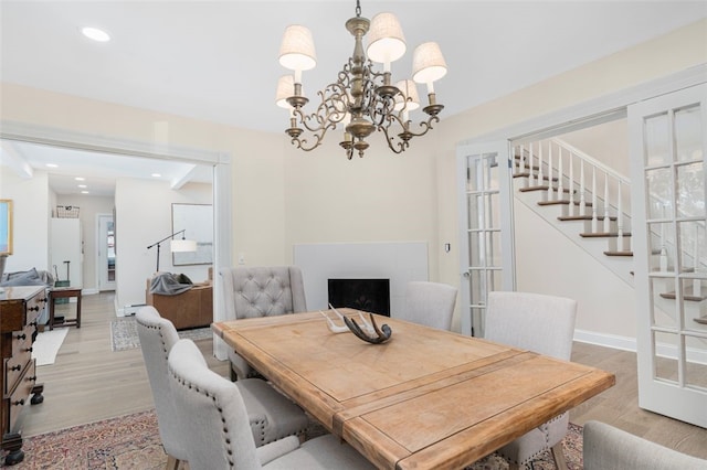 dining area featuring recessed lighting, a fireplace, baseboards, light wood-style floors, and stairway