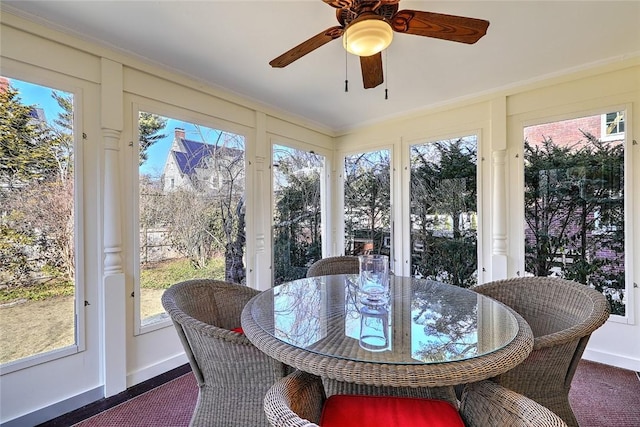 sunroom / solarium featuring a healthy amount of sunlight and ceiling fan