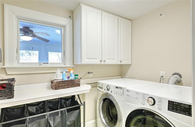 washroom featuring ceiling fan, washing machine and dryer, and cabinet space