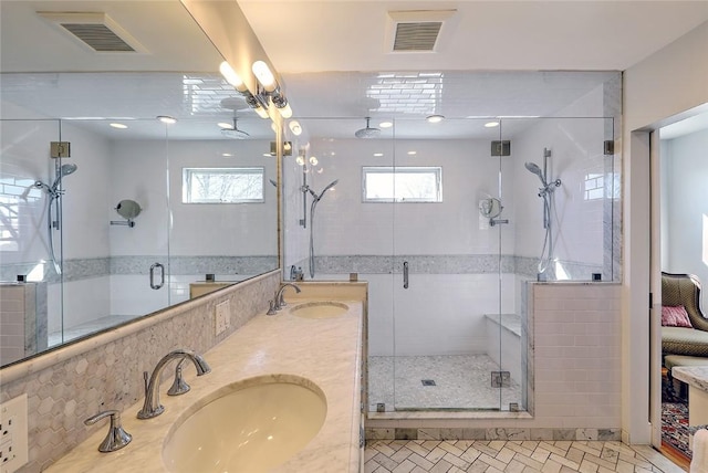 full bathroom with a wealth of natural light, a sink, and visible vents