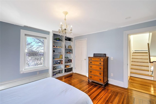 bedroom with dark wood-style floors, crown molding, a chandelier, and baseboards