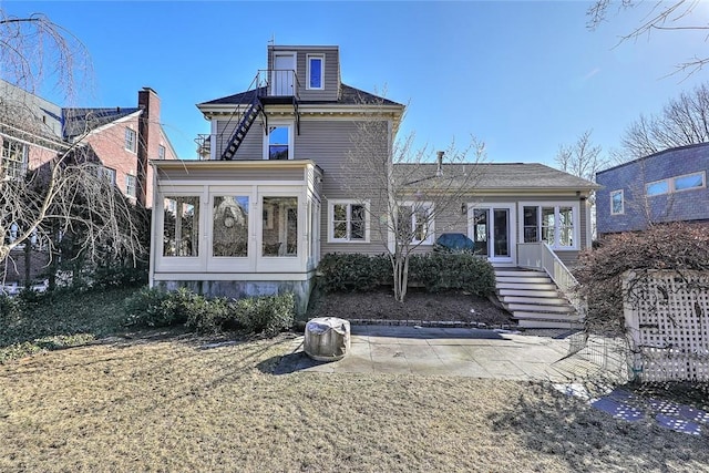 rear view of house with a sunroom and stairs