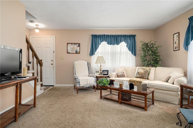 living area featuring carpet, baseboards, and stairs