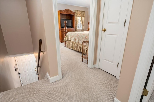 hall featuring baseboards, light carpet, and an upstairs landing