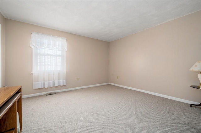 carpeted empty room with visible vents and baseboards