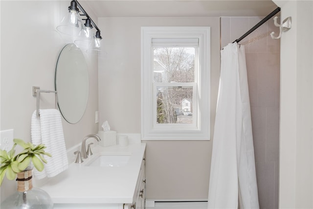 bathroom featuring tiled shower, vanity, and baseboard heating