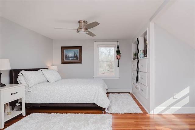 bedroom featuring dark wood-style floors, ceiling fan, and baseboard heating