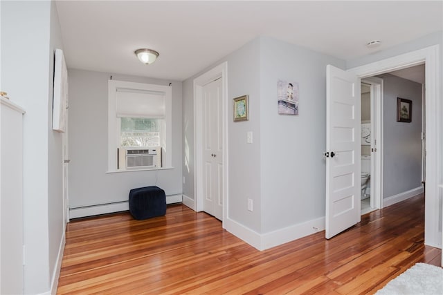 interior space featuring light wood finished floors, baseboard heating, and baseboards