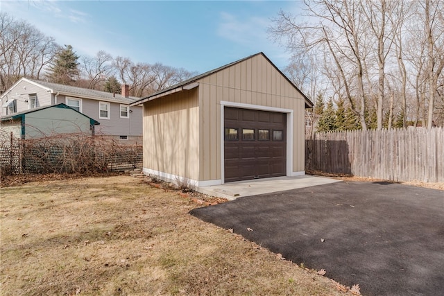 detached garage with aphalt driveway and fence