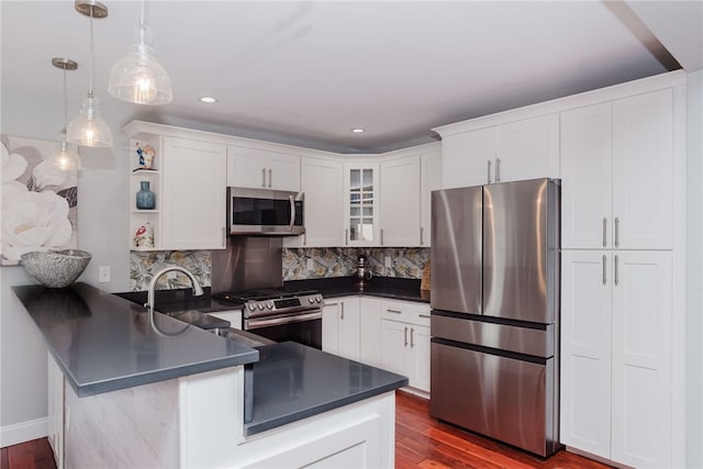 kitchen with open shelves, dark countertops, appliances with stainless steel finishes, white cabinets, and a peninsula