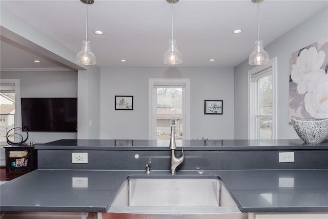 kitchen with dark countertops, a healthy amount of sunlight, a sink, and recessed lighting