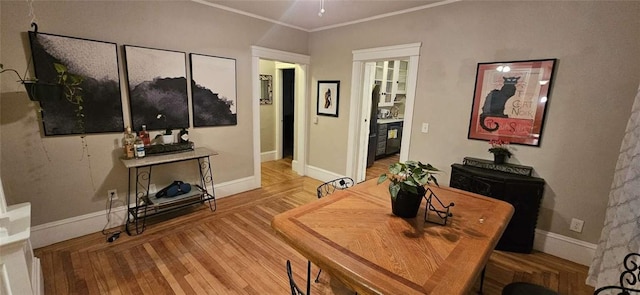 dining area with crown molding, a ceiling fan, baseboards, and wood finished floors