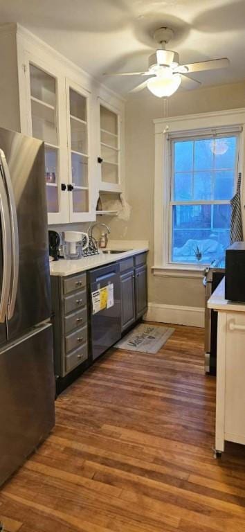 kitchen with wood finished floors, freestanding refrigerator, a sink, and black dishwasher