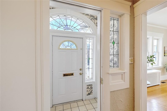 foyer featuring a healthy amount of sunlight, visible vents, and ornamental molding