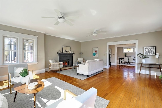 bedroom featuring light wood finished floors, a fireplace, baseboards, and crown molding