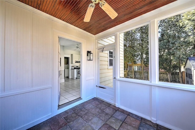 unfurnished sunroom featuring wood ceiling and ceiling fan