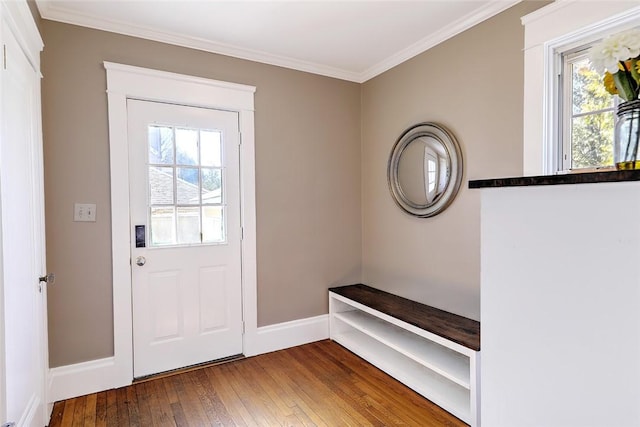 doorway with ornamental molding, a healthy amount of sunlight, baseboards, and hardwood / wood-style flooring