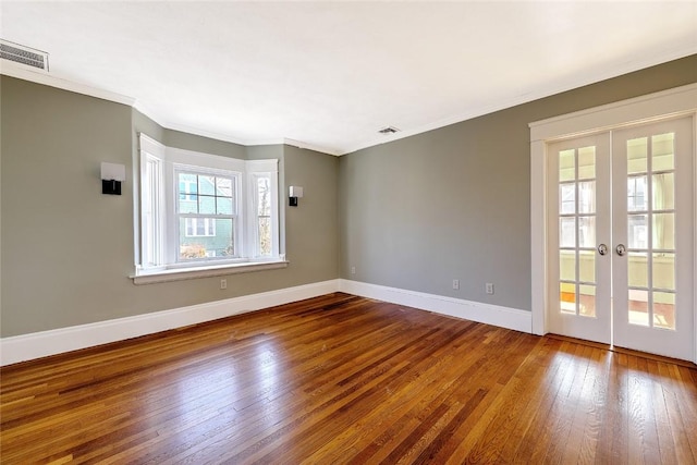 spare room featuring baseboards, visible vents, hardwood / wood-style floors, and french doors