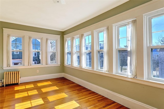 unfurnished sunroom with radiator heating unit and a wealth of natural light